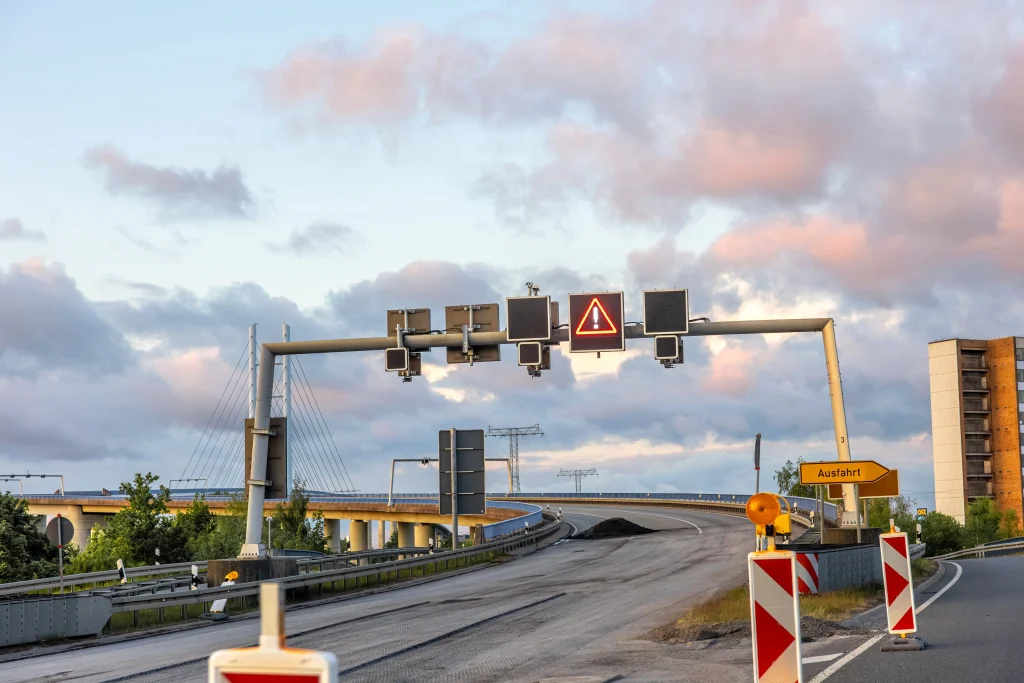 Bridge monitoring sensors measuring vibration, strain, and structural movement with real-time data displayed on a monitoring system.